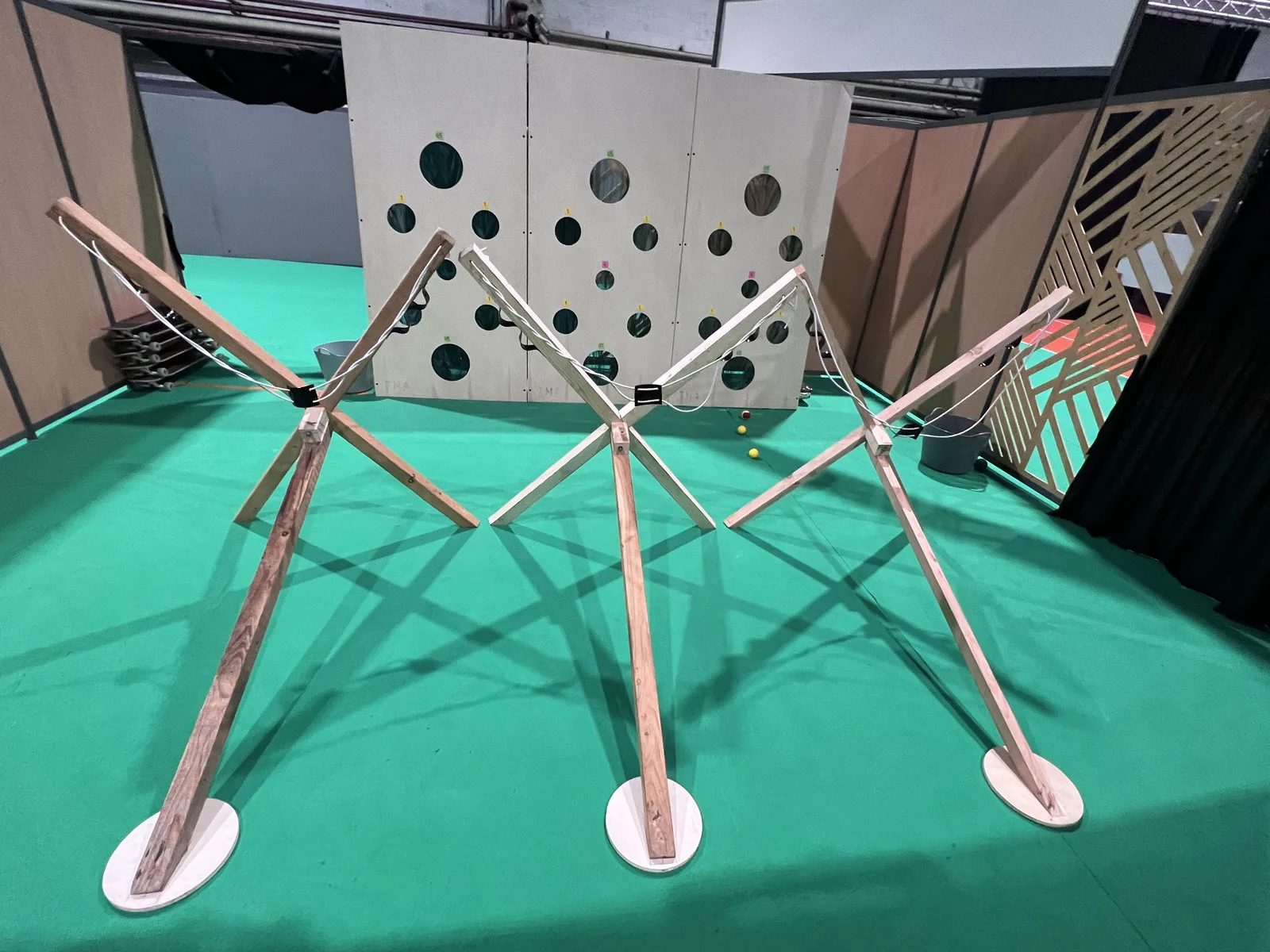 Lance-balles géants en bois face à une cible à trous, atelier d'adresse et de précision des jeux en bois Terre-Mer Aventure à Quiberon Bretagne Sud