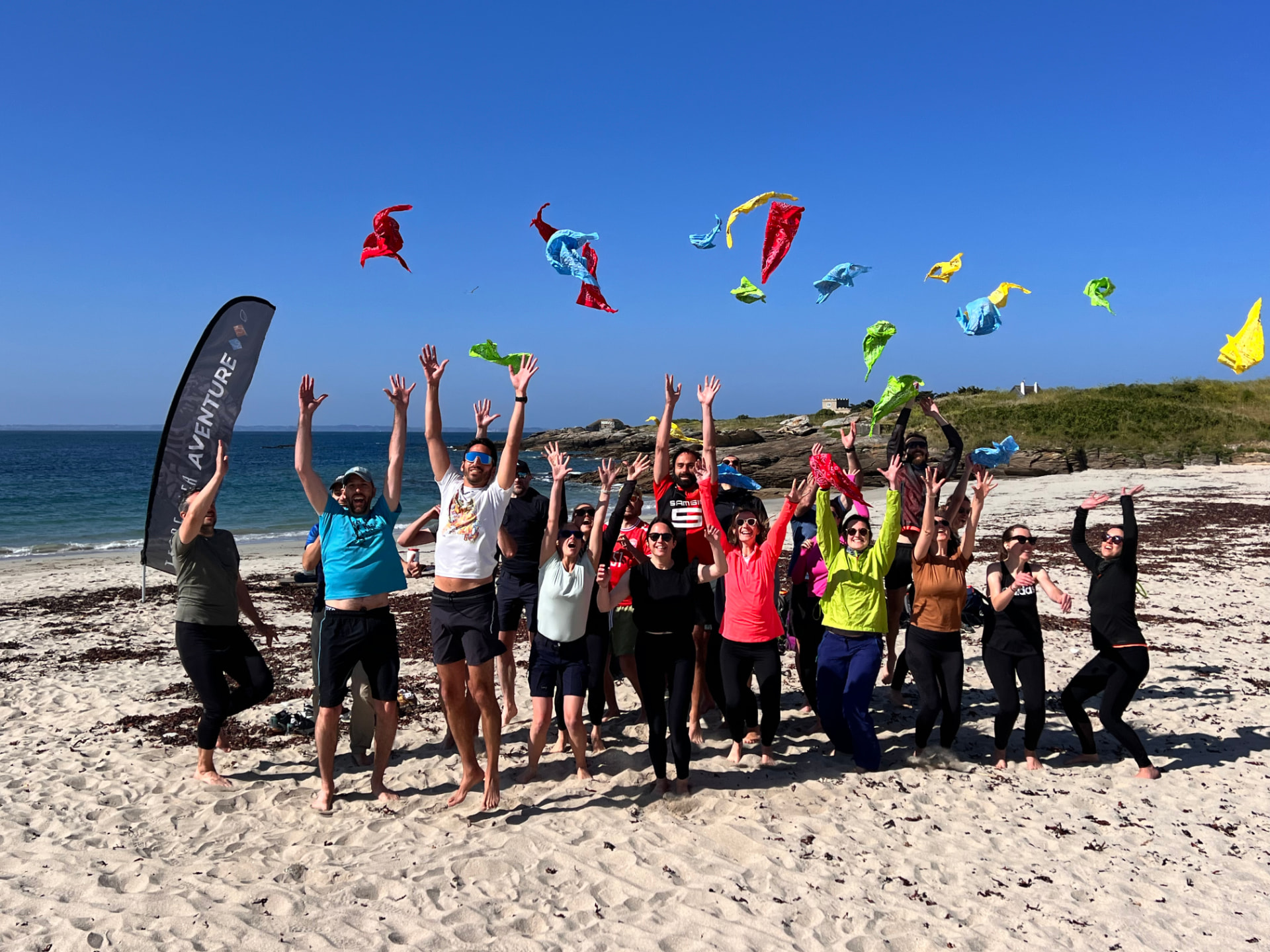 Olympiades : groupe en pleine célébration sur la plage de Penthièvre, bandanas en l'air et esprit d'équipe