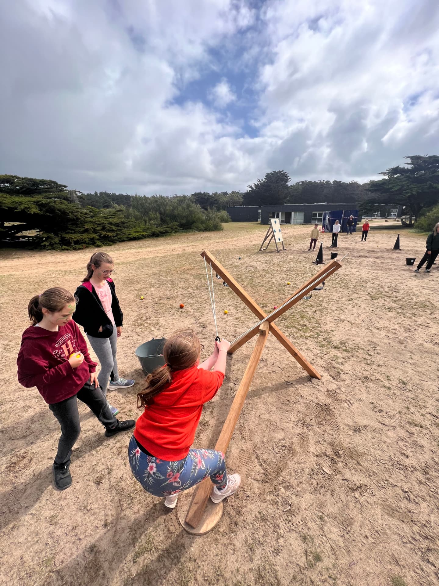 Défi des dunes : enfants visant des cibles XXL avec un lanceur en bois sur la plage de Penthièvre