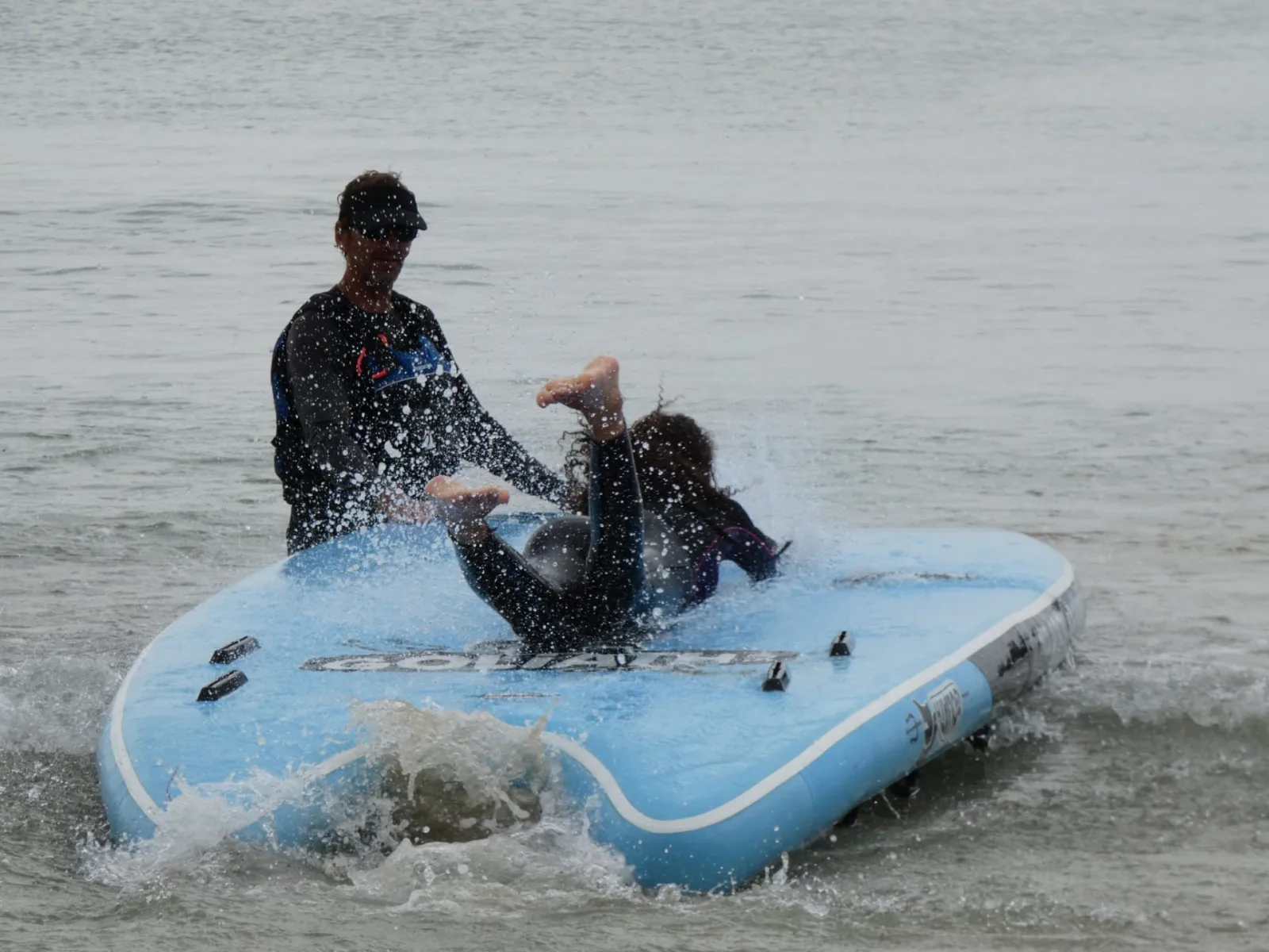 Éclaboussures et rigolade sur une planche Goliath lors d'une séance de jeux nautiques dans la baie de Quiberon Bretagne Sud