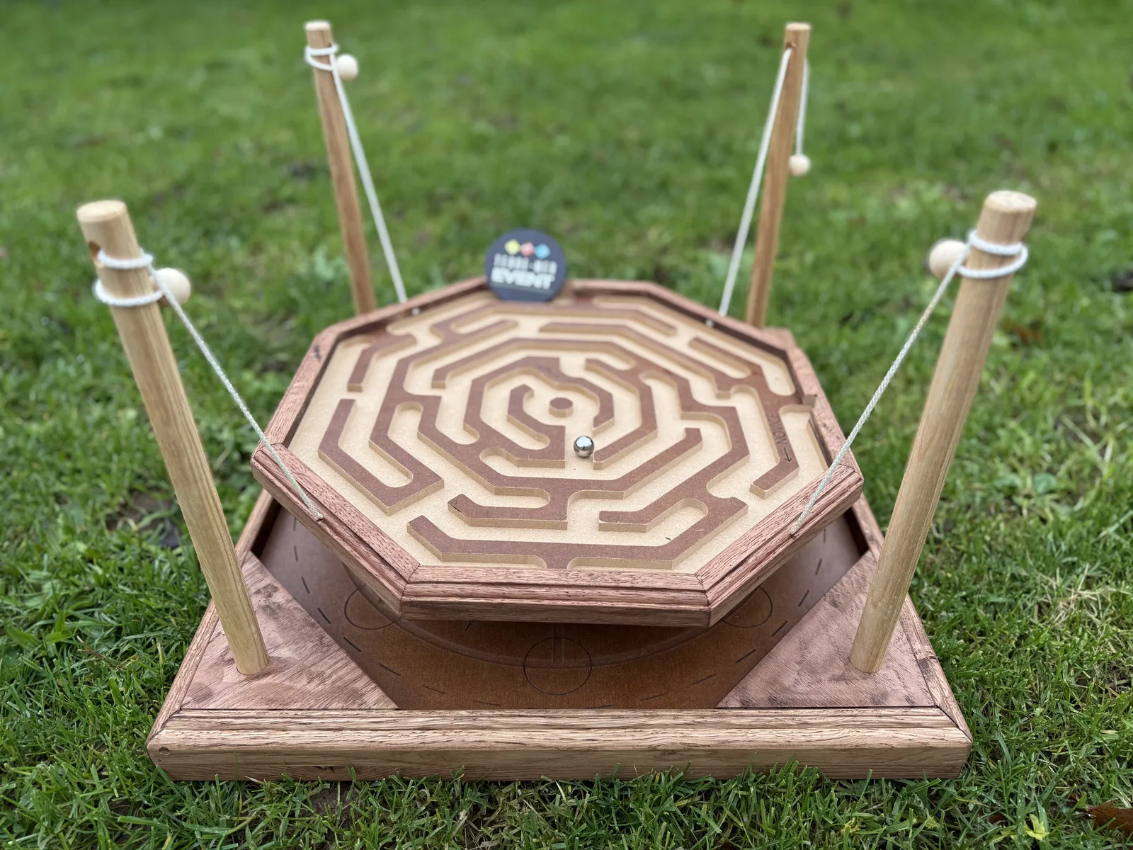 Jeu en bois géant coopératif : labyrinthe octogonal piloté par cordes pour guider une bille, animation Terre Mer Aventure sur la presqu'île de Quiberon