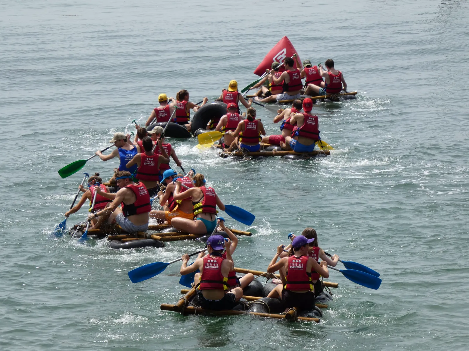 Course de radeaux Terre Mer Aventure — équipes en cohésion pagayant en mer à Quiberon