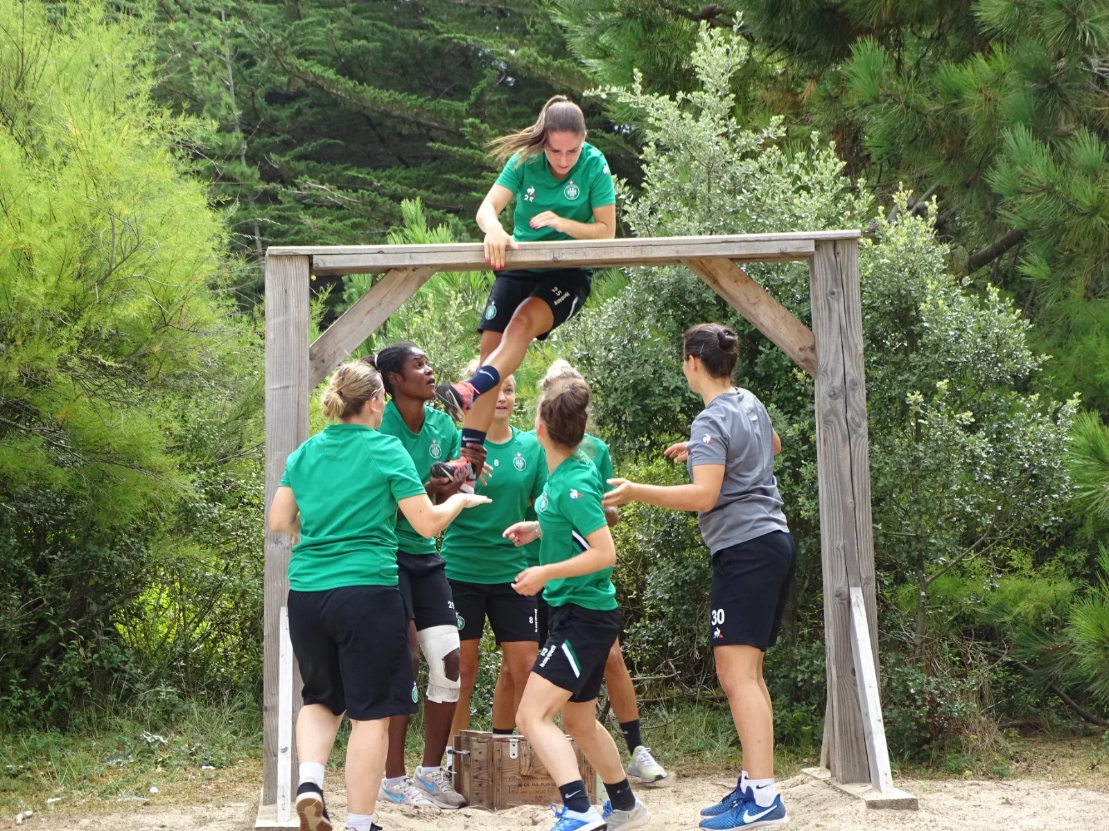 Boot camp : équipe de femmes franchissant un parcours d'obstacles en bois dans un cadre naturel à Quiberon Bretagne Sud