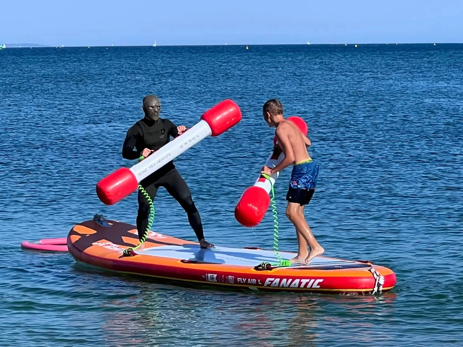 Joute sur paddle géant avec bâtons gonflables lors d'une séance de jeux nautiques en Baie de Quiberon