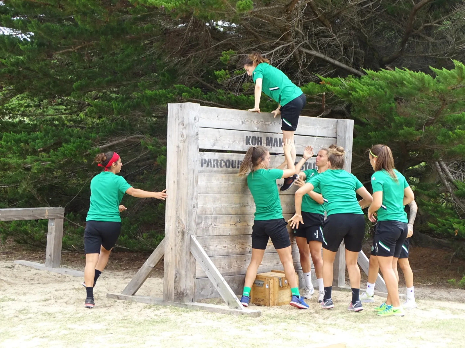 Boot camp : équipe de femmes franchissant un parcours d'obstacles en bois dans un cadre naturel à Quiberon Bretagne Sud