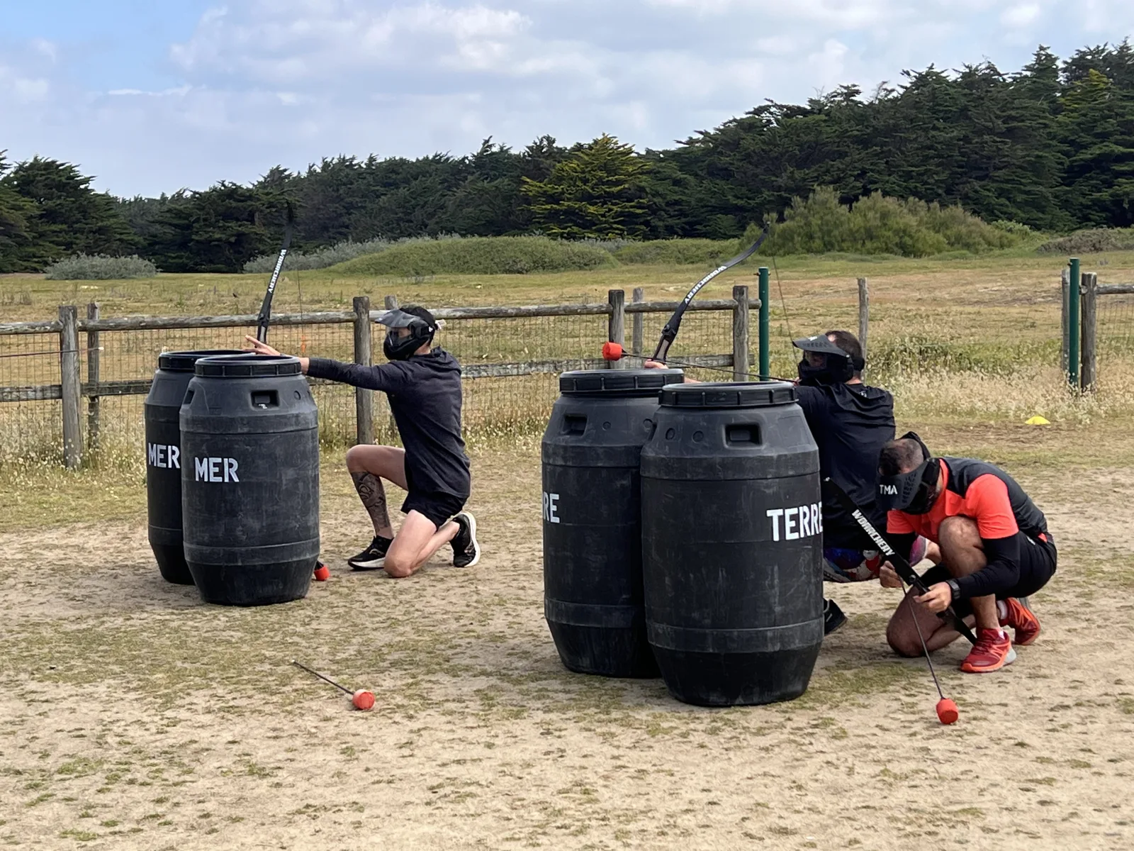 Battle Archery : trois joueurs équipés de masques et de boucliers « Terre » et « Mer » lors d'une partie d'Archery Tag à Quiberon Bretagne Sud